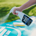 Person spaying the iROCKER SUP Cleaner & Protectant to their board